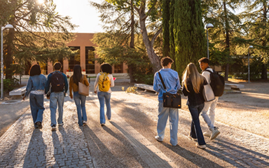 College kids walking across a school campus.