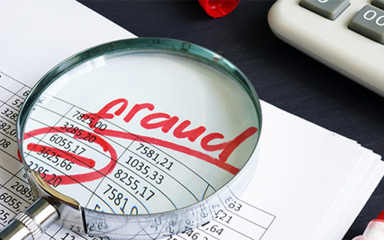 A magnifying glass with the word fraud in the middle.