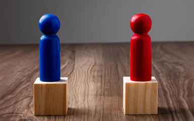 Wooden people on wooden blocks.