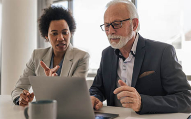 Two business professionals looking at a laptop.
