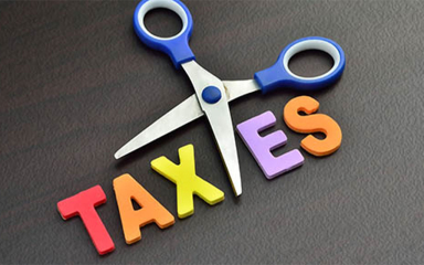 Scissors cutting the word Taxes