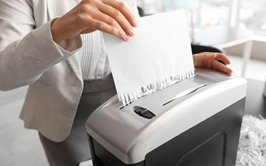 A business person shredding document.