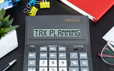 A calculator on a desk with office items.