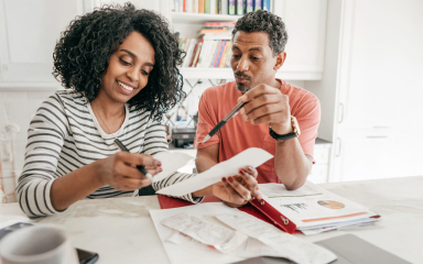 Two people at a table reviewing receipts.