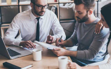 business professionals meeting and looking at a notepad.