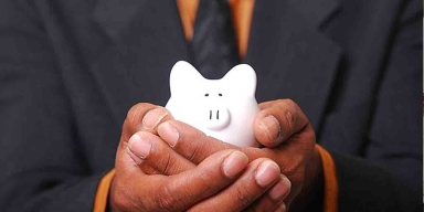 man with tie holding a piggy bank
