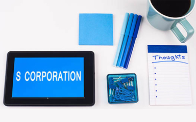 Tablet, sticky notes, cup of coffee, paper clips, pens and a notepad.