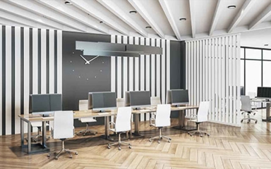 An open style office with a long desk house several computers and chairs.