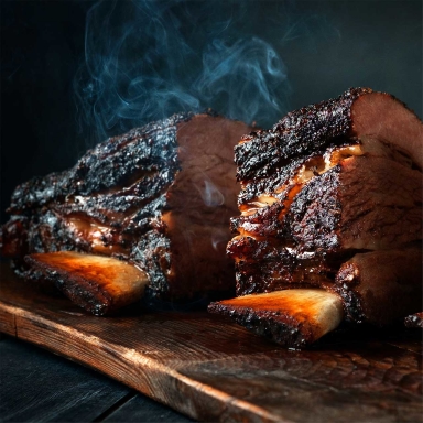 smoked BBQ ribs steaming and sitting on a wood plank