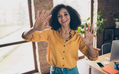 A woman holding up her hands, showing all of her fingers.