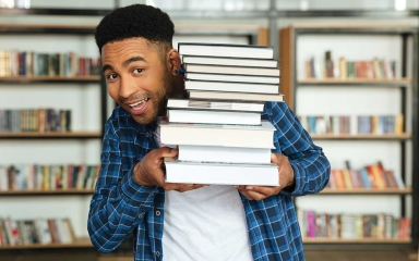 A man holding a stack of books.