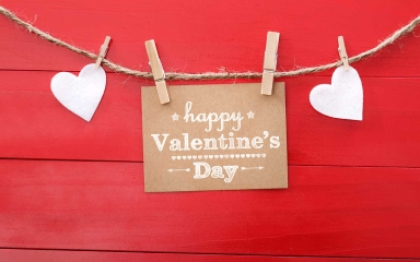 A rope with paper hearts and a note being held on by clothes pins.