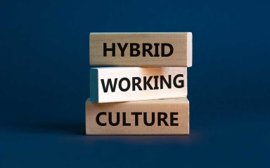three building blocks with the words hybrid working culture printed on them with a dark blue background