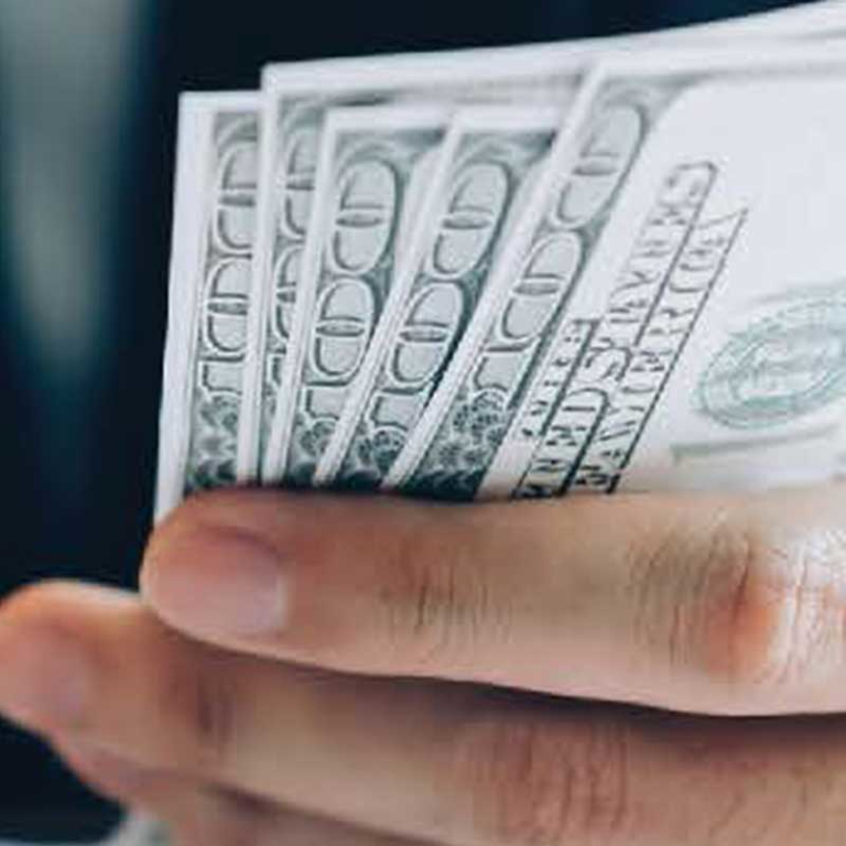 man holding stack of 100 US bills