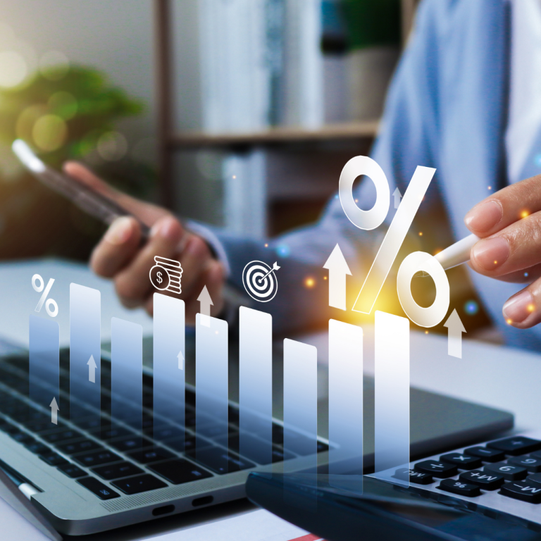 A small business owner looking at his computer and phone reviewing financial data.