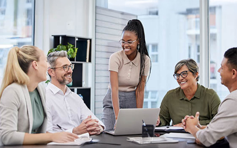Business professionals in a meeting room, smiling.