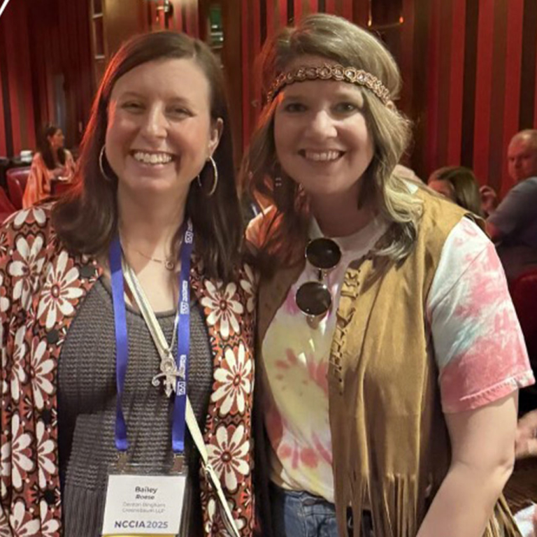 Two women dressed in 70's style attire at a party.