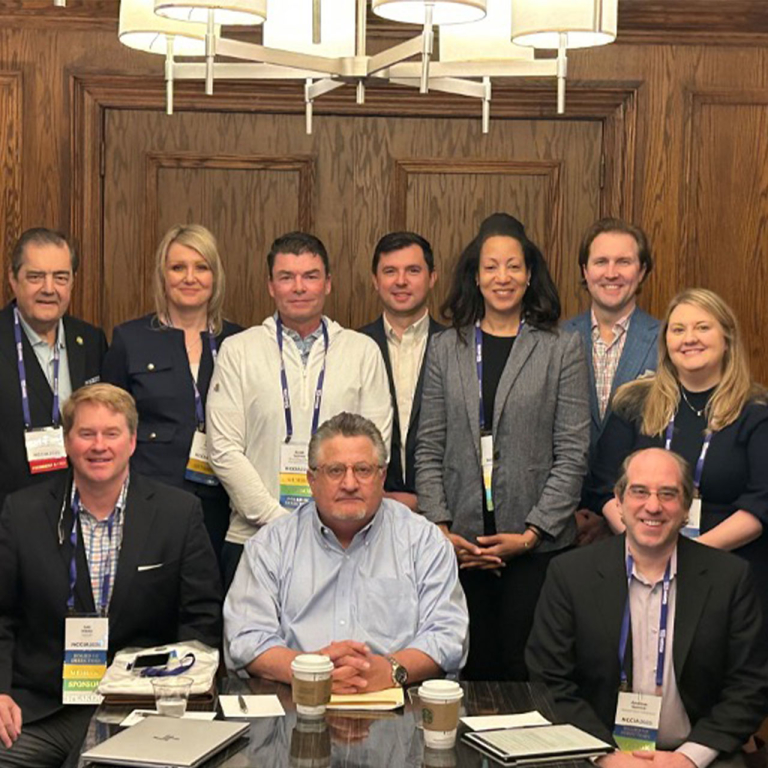 Professionals posing for a photo in a board room.