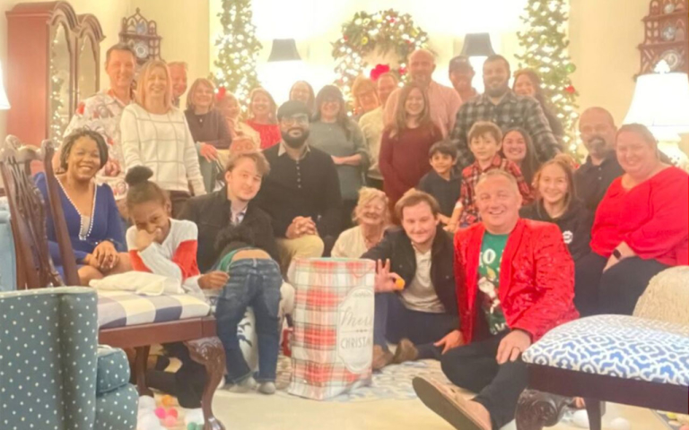 Group photo with people wearing Christmas attire.