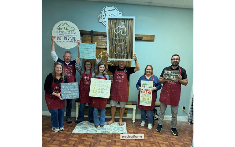 A group of people holding art they made.