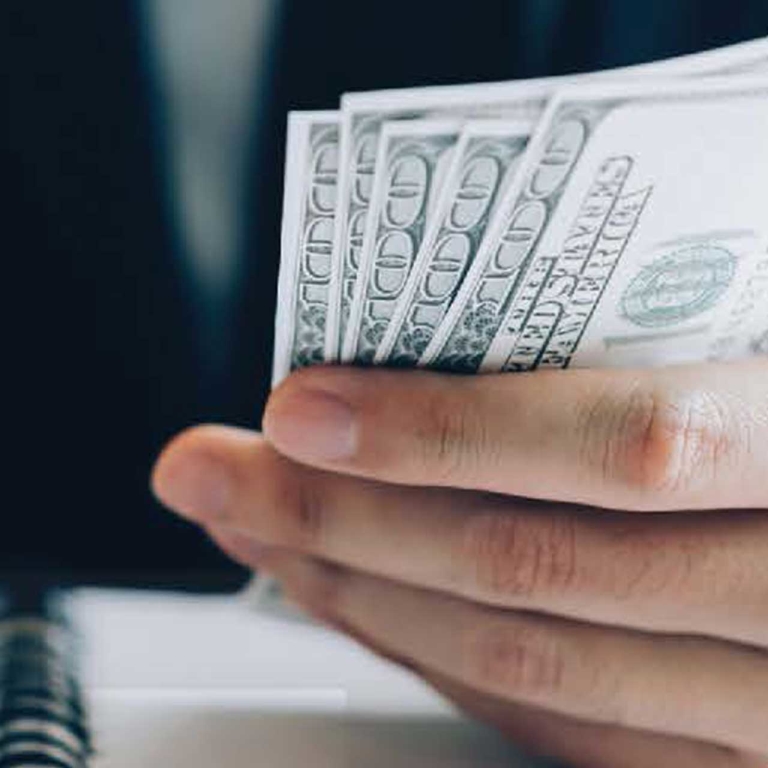 man holding stack of 100 US bills