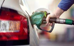 Hand holding a gas pump, filling up a car.