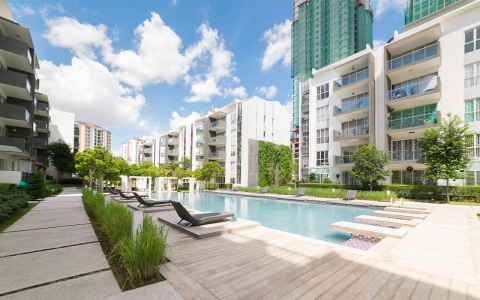 A pool surrounded by condo buildings.