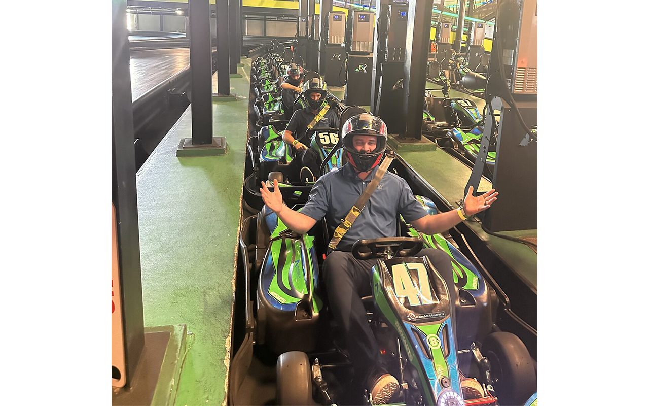 Three men in Go Carts, wearing helmets.