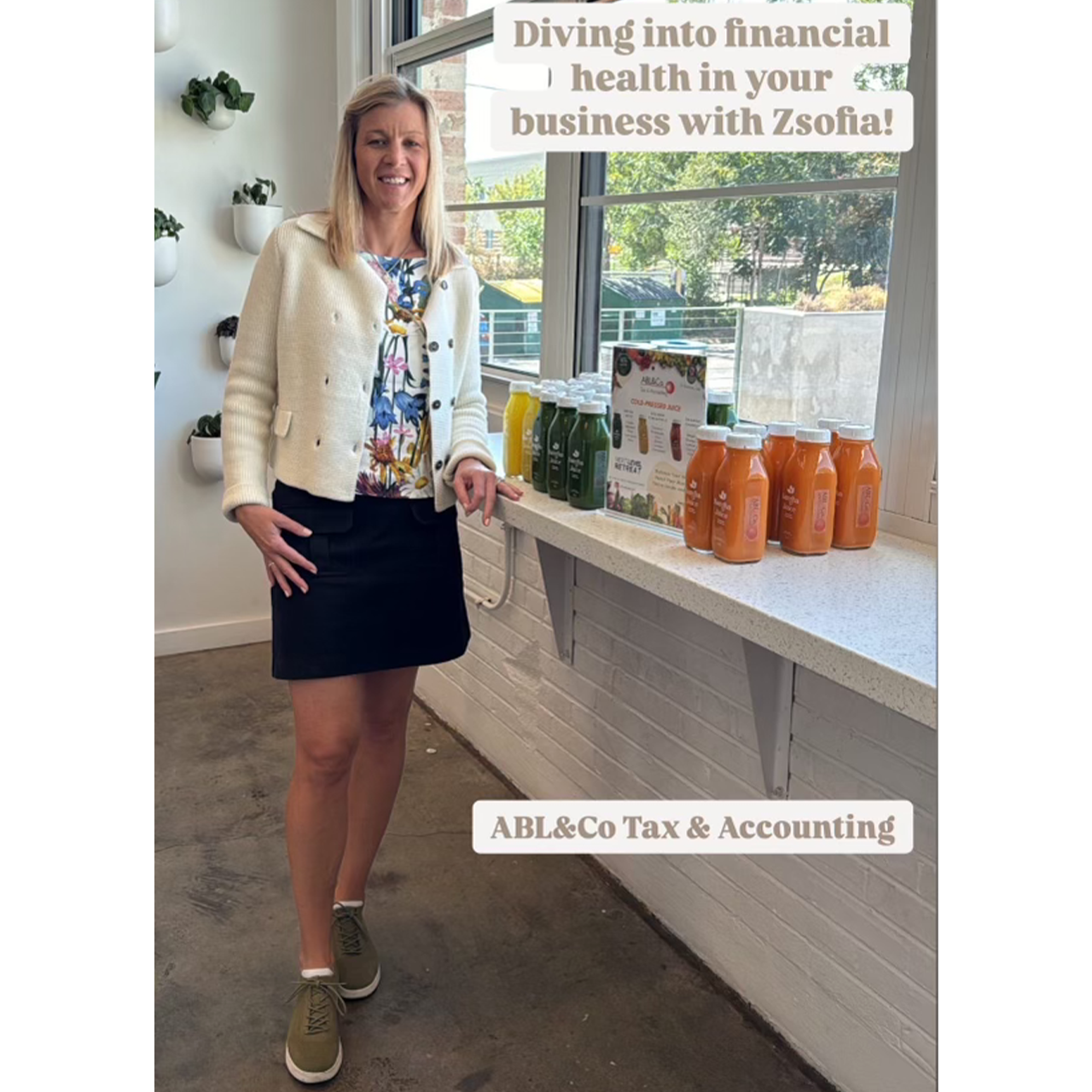 A woman standing next to a counter with different bottled juices on it.