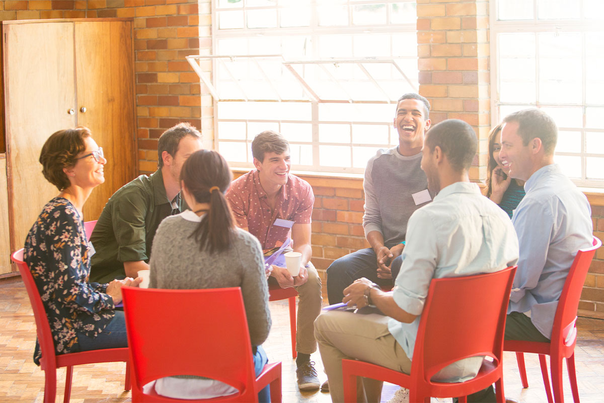 People sitting in a circle, laughing.