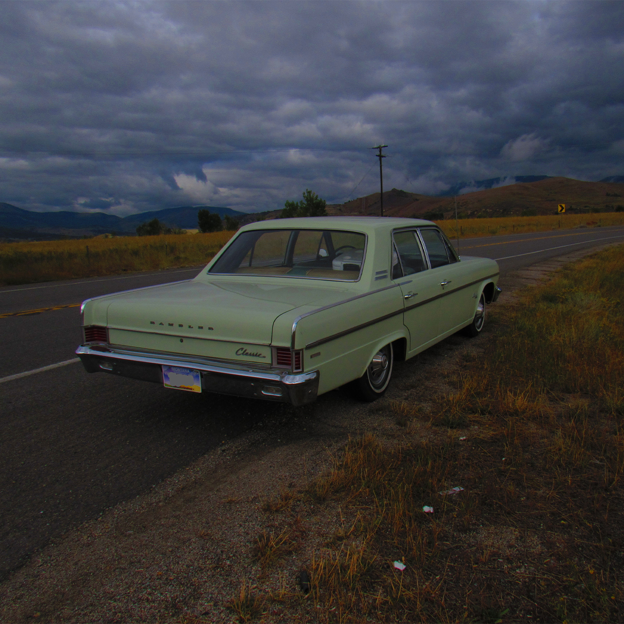 An old car pulled off to the side of a country road.