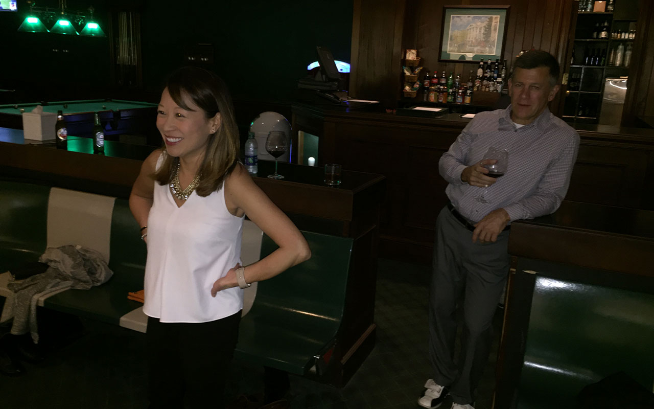 A man and woman standing at the bar in a bowling alley.