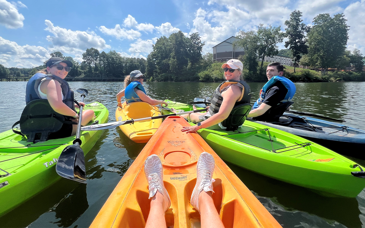 Group of people kayaking on a lake.
