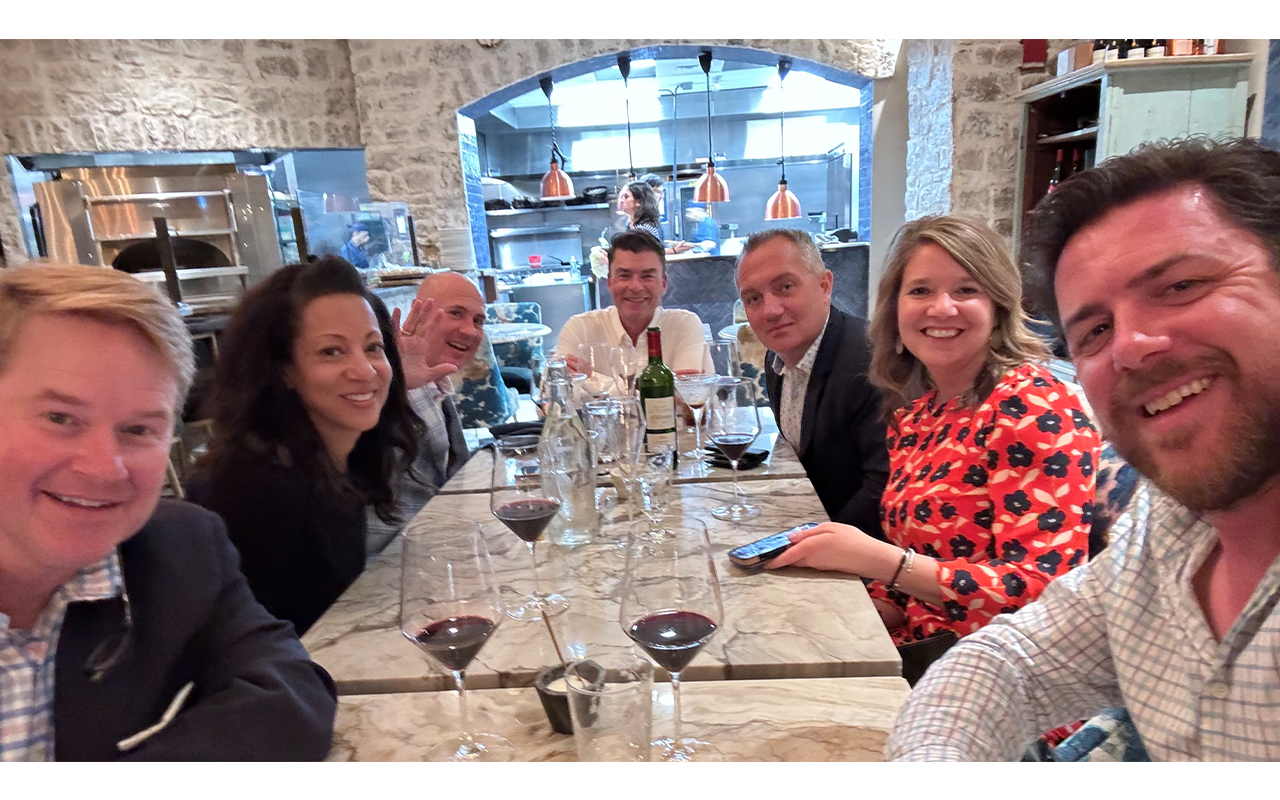 A group of people with glasses of wine at a table in a restaurant.