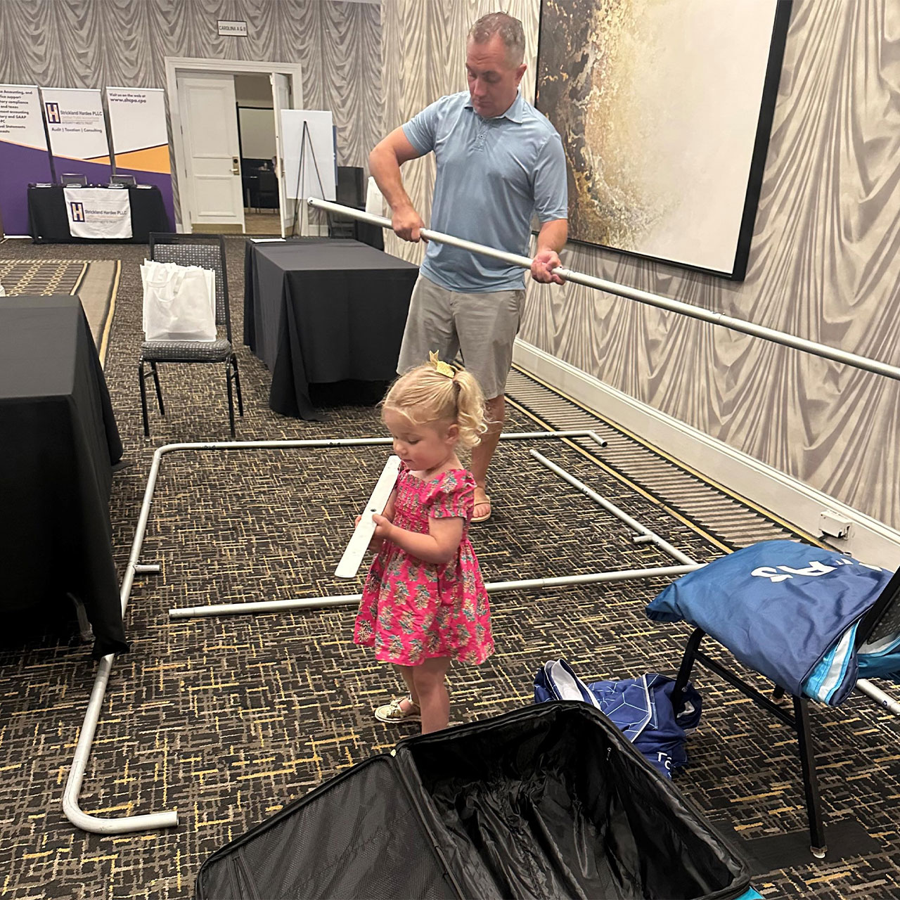 Two people setting up a booth.