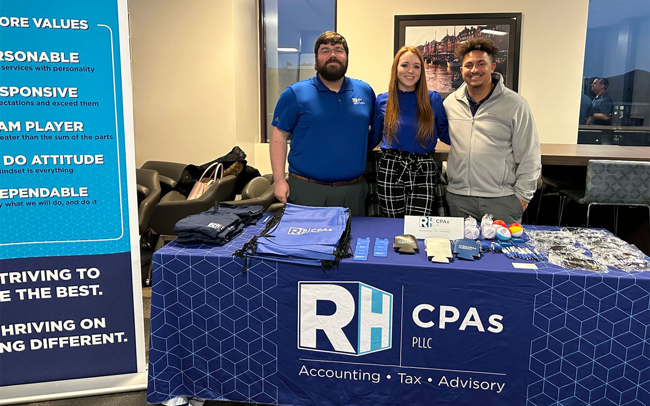 Tax professionals at a booth at a college campus