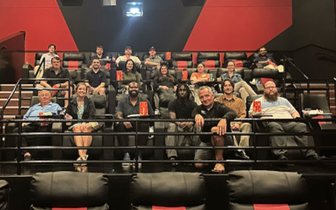 A group of people with popcorn in a movie theater.