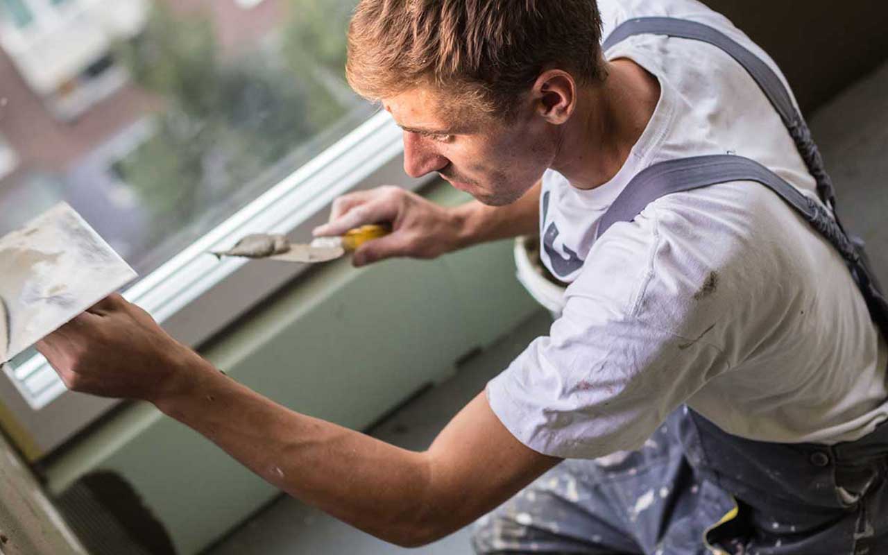 Service-based worker doing texture work on a wall