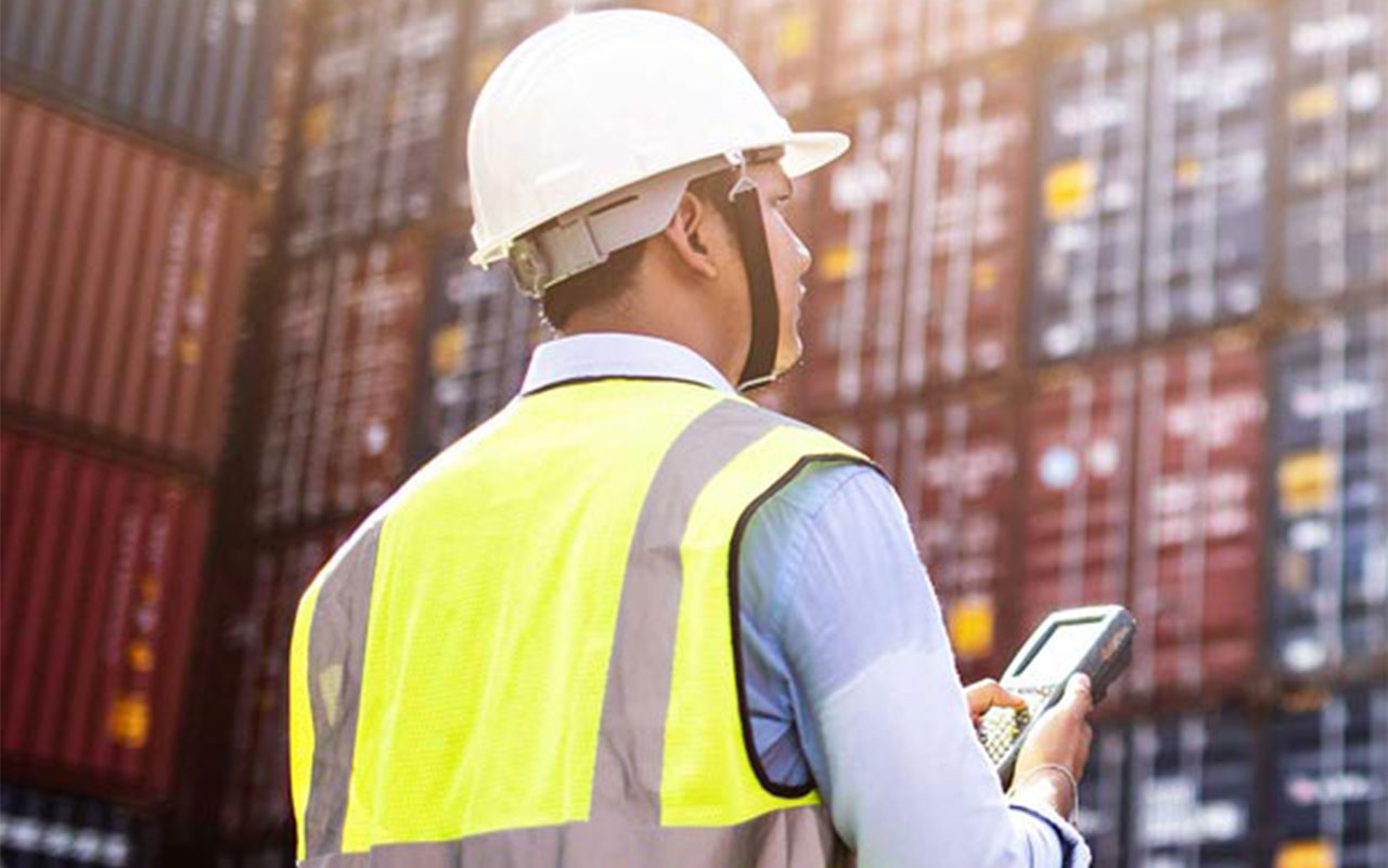 Man wearing a hardhat taking inventory.