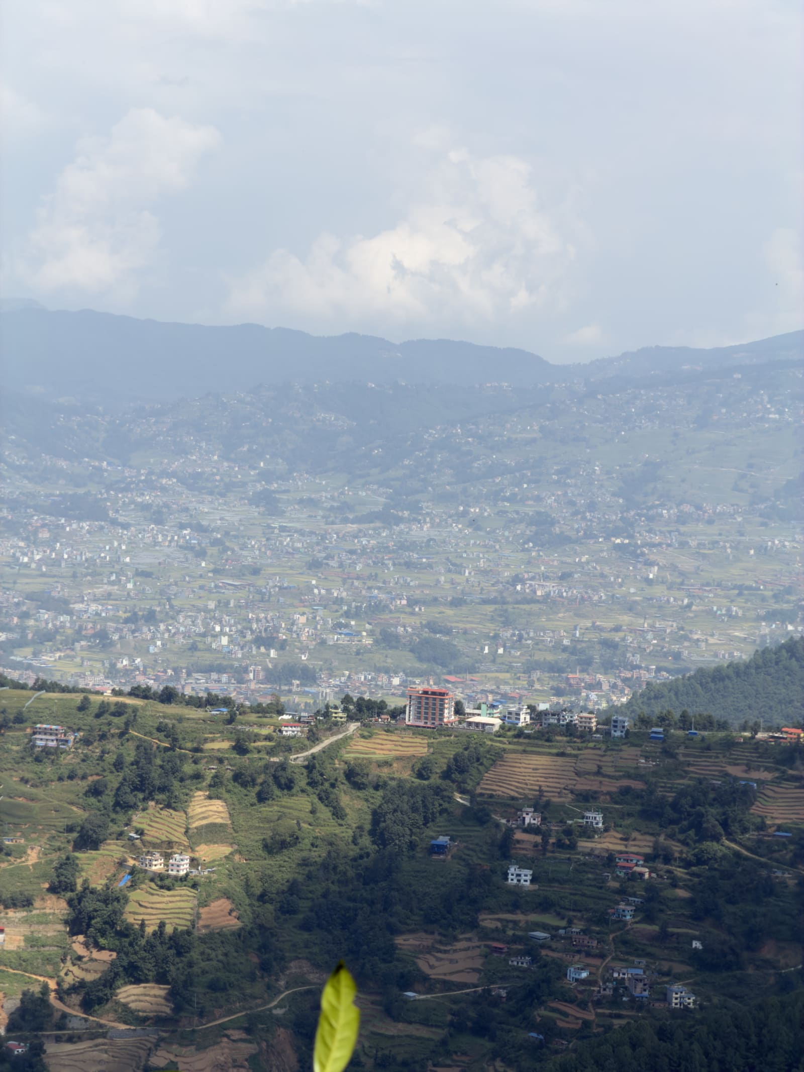 Panoramic view of terraced hills, scattered houses, and distant mountains in Kathmandu Valley