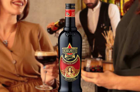 Eine Flasche Caffè-Borghetti-Kaffeelikör vor Menschen mit Espresso-Martini-Cocktails.