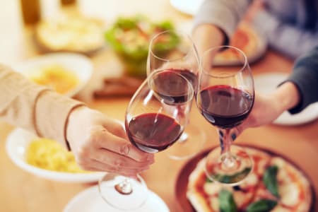 Pizza und drei Gläser Rotwein