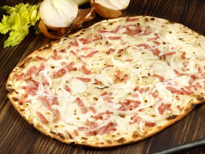 Traditioneller französischer Flammkuchen mit Crème Fraîche, Zwiebeln und Speck.