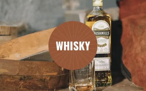 Eine Flasche Bushmills Whisky mit Glas.