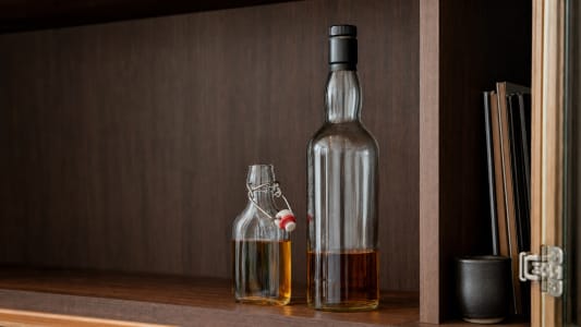 Eine kleine und eine große Flasche Whisky im Regal.