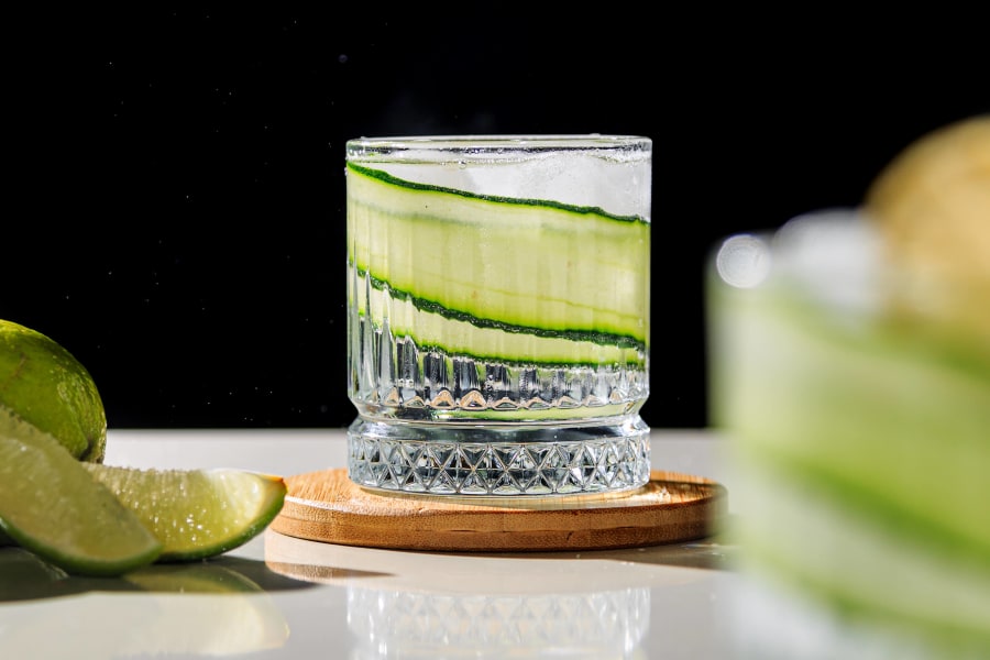 Drei Cocktails stehen auf einer Bartheke.