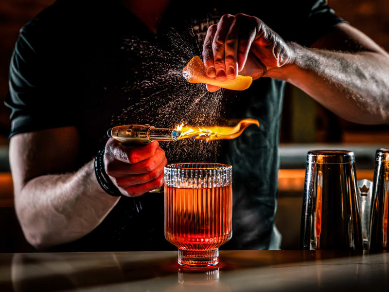 Drei Cocktails stehen auf einer Bartheke.