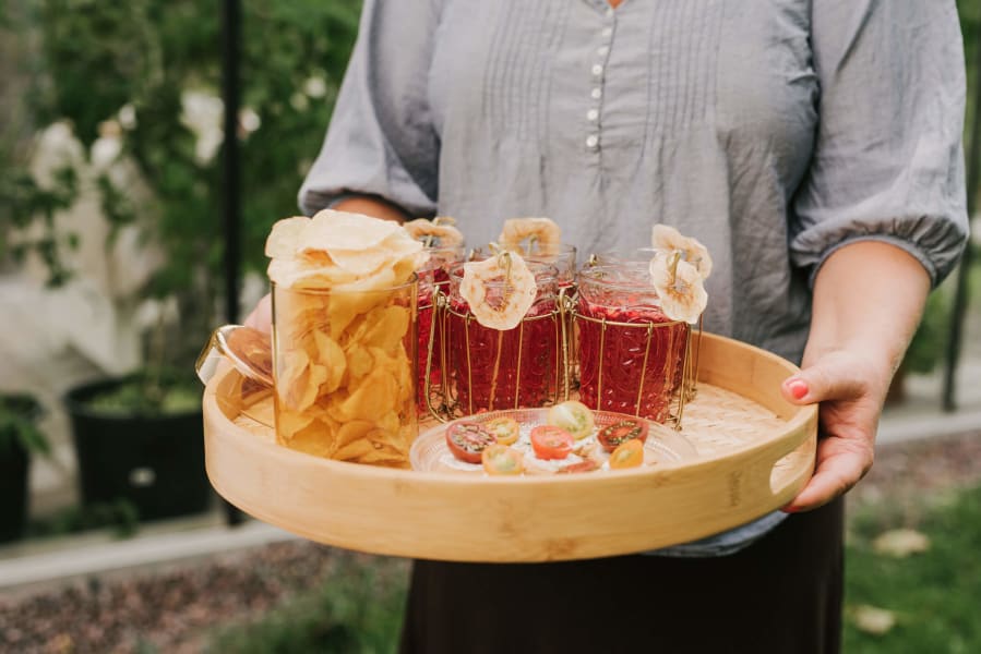 Rote Aperitifs und Snacks werden auf einem Tablett gebracht.