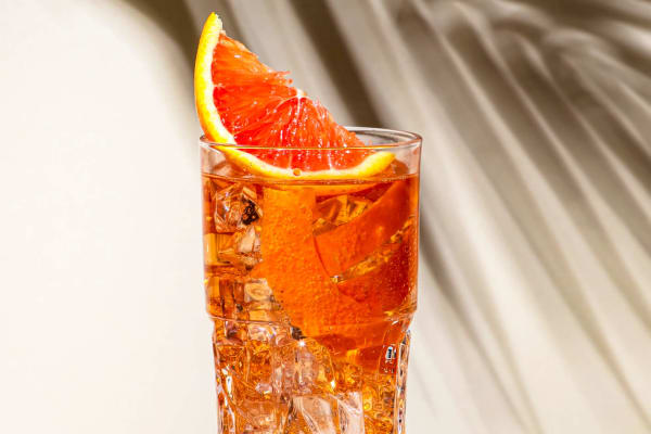 Ein Sazerac-Cocktail mit Blutorange als Garnitur.