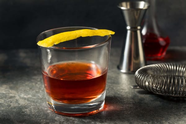 Sazerac-Cocktail mit Zitronenzeste garniert.